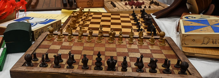 Two chess boards surrounded by other board games and boxes